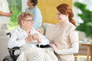 home healthcare nurse talking and smiling with elderly patient