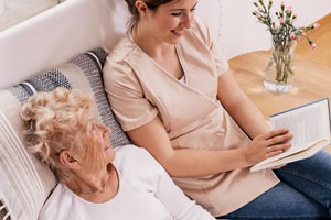 hospice volunteer reading book to patient